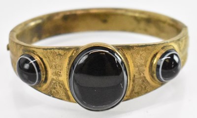 Lot 1326 - A pinchbeck bangle set with three black...