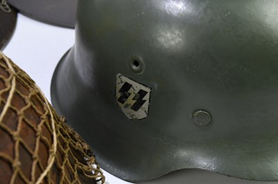 Lot 435 - A reproduction German WWII helmet with three...