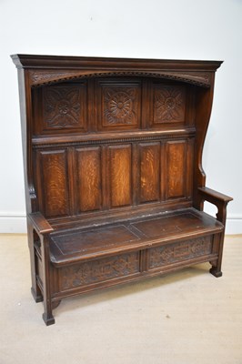 Lot 1044 - A 20th century oak settle with raised back and...