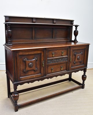 Lot 1258 - A 1920s oak sideboard with raised back above...