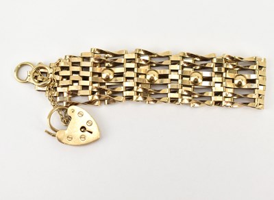 Lot 1046 - A 9ct gold six-bar gate bracelet with safety...