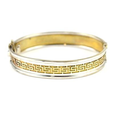 Lot 1039 - A 9ct white gold hinged bracelet with central...
