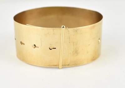Lot 1049 - A 9ct gold plain wide bracelet, with four...