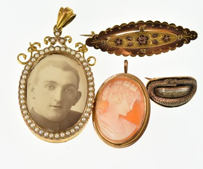 Lot 1065 - Three gold brooches comprising a small...