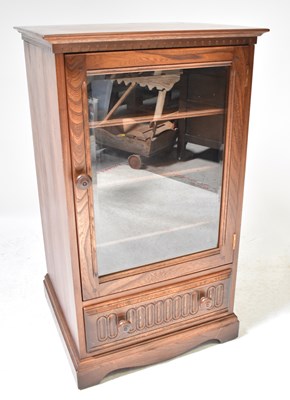 Lot 1 - ERCOL; a dark stained oak glazed side cabinet...
