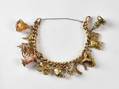 Lot 1036 - A 15ct yellow gold charm bracelet suspending...
