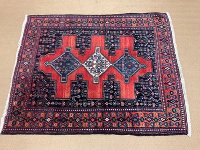 Lot 700 - A Sennah Persian rug with triple medallion...