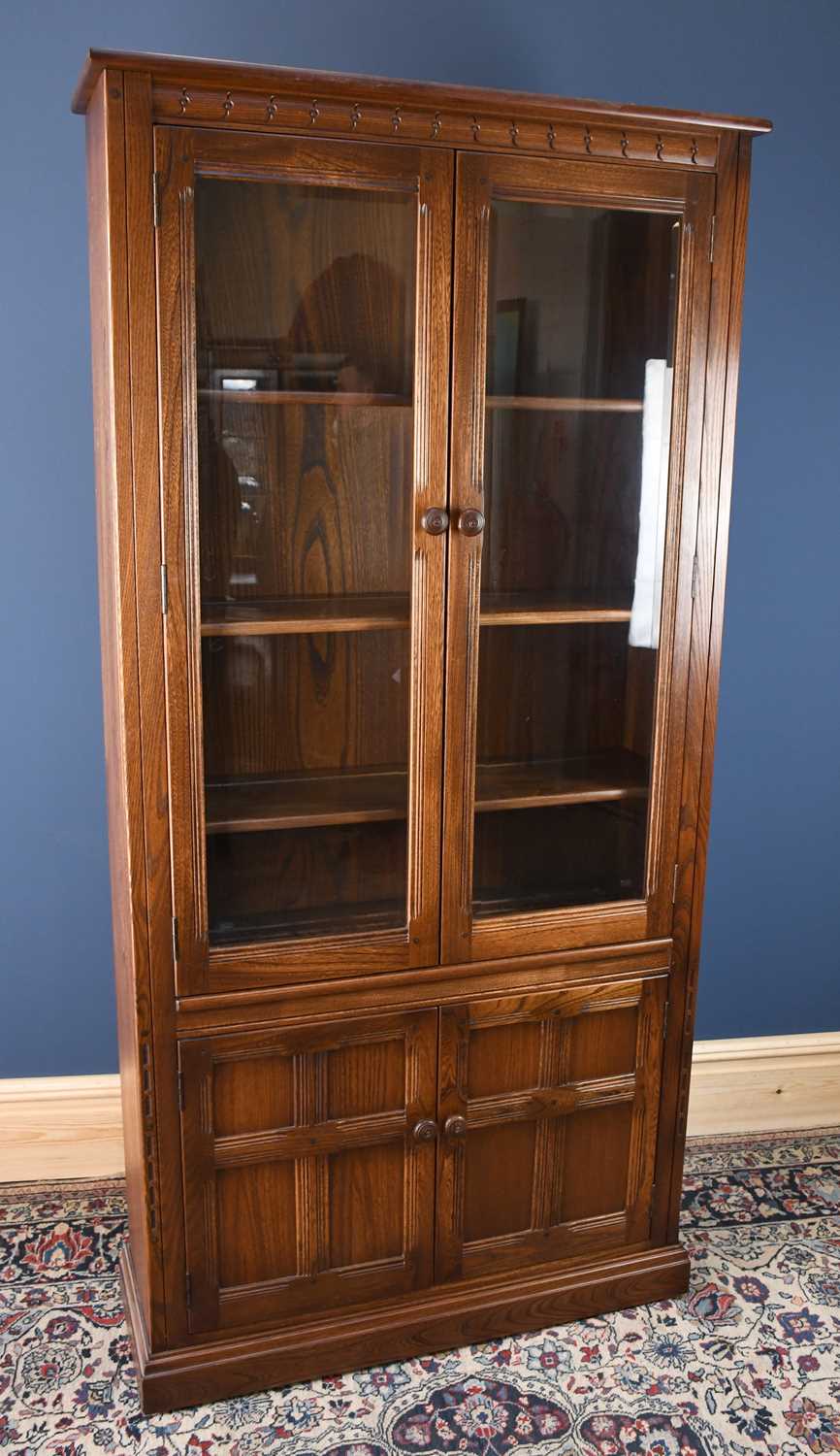 Lot 3046 - An Ercol style oak display cabinet with two...