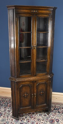 Lot 3056 - A 1920s oak corner cabinet, with two glazed...