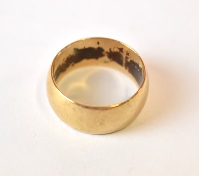 Lot 613 - A broad 9ct yellow gold wedding band, size R,...