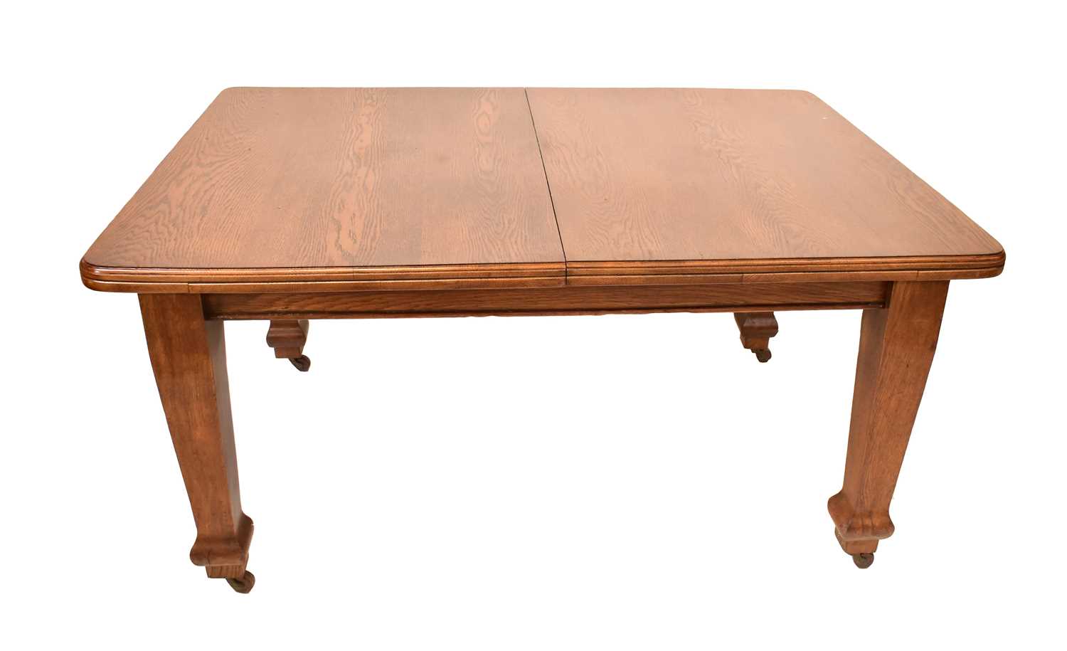 Lot 29 - A large early 20th century oak wind-out table...
