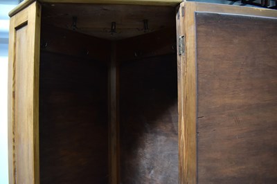 Lot 31 - A pine corner wardrobe with bevelled mirror...