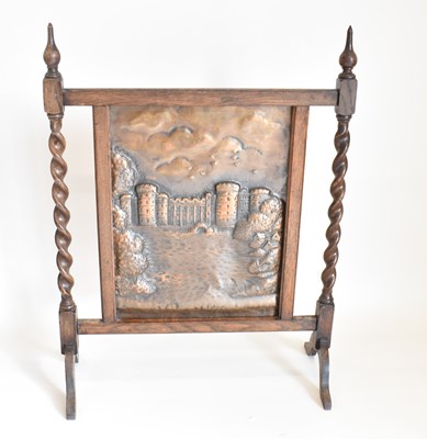 Lot 59 - A bronzed and oak fire screen with repoussé...