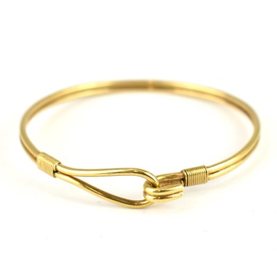 Lot 1040 - A 9ct gold double tube bracelet, with hook and...