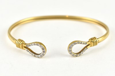 Lot 1055 - A gold-coloured metal bracelet with hoop ends...