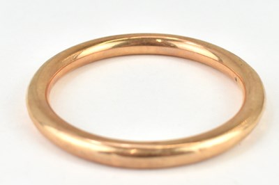 Lot 1037 - A 9ct rose gold hollow bangle, internal...