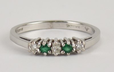 Lot 1005 - An 18ct white gold emerald and diamond set...
