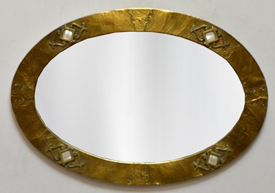 Lot 1034 - An Arts & Crafts hammered brass framed oval...