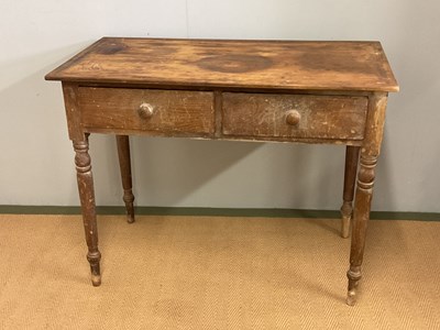 Lot 802 - An old pine table with two drawers, on turned...