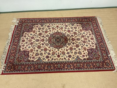 Lot 703 - A Persian rug with a central floral design,...