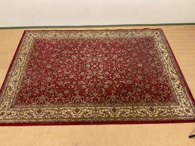 Lot 704 - A Persian style rug with floral scrolled...