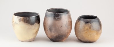 Lot 382 - LIZ ANSPOKS; a graduated trio of smoke fired...