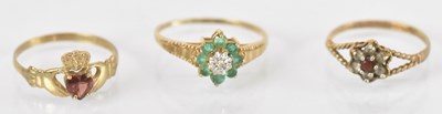 Lot 1275 - A 9ct yellow gold red stone set dress ring,...