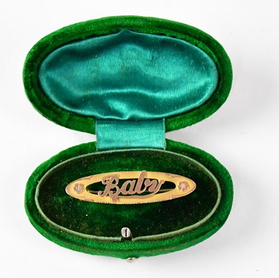 Lot 788 - A two-tone gold oval brooch inscribed 'Baby',...