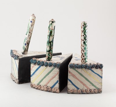 Lot 677 - Three raku slices of cake with candles,...