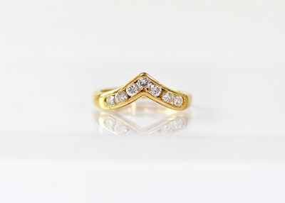 Lot 902 - An 18ct gold wishbone ring channel set with...