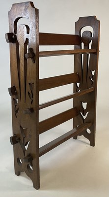 Lot 776 - An Arts and Crafts oak three shelf open...