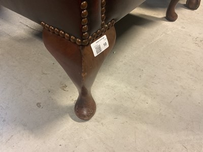 Lot 10 - A modern oxblood red leather button wing back armchair