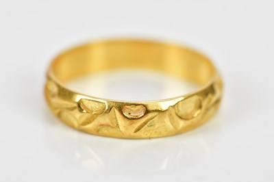 Lot 127 - An 18ct yellow gold wedding band with embossed...