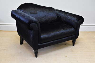 Lot 1055 - A modern black lounge chair on turned columns.