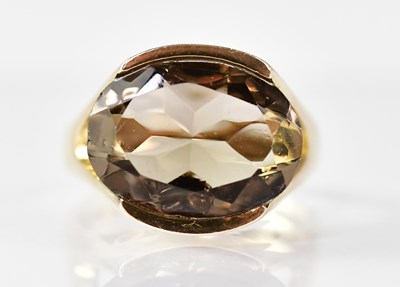 Lot 884 - A 9ct yellow gold ring set with an oval smoky...