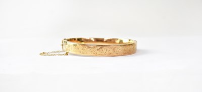 Lot 771 - A 9ct gold hinged bracelet, half decorated...