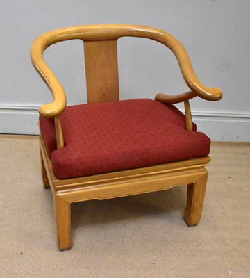 Lot 1094 - A modern Chinese elm horseshoe back elbow chair.