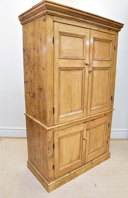 Lot 1151 - An old waxed pine press cupboard, with a pair...