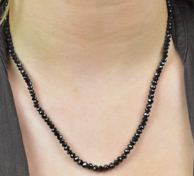 Lot 1090 - A graduated cut black onyx necklace with 18ct...