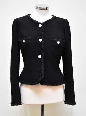 Lot 886 - CHANEL; a black wool and silk mix short bouclé...
