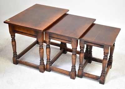 Lot 31 - A reproduction oak nest of three tables with...