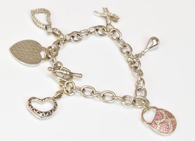 Lot 1118 - A white metal charm bracelet set with both...