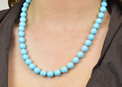 Lot 1125 - A turquoise hand tied bead necklace with white...