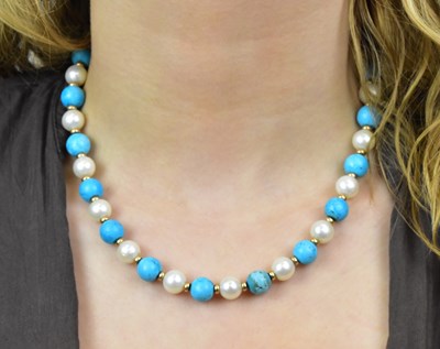 Lot 1128 - A turquoise and pearl bead necklace with...