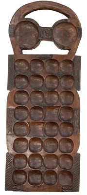 Lot 568 - An African Mancala Oware board, 64 x 24.5cm.