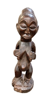 Lot 569 - An African wooden carving of a pregnant female,...