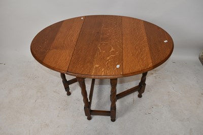 Lot 1569 - A 1920s oak drop-leaf gateleg dining table on...
