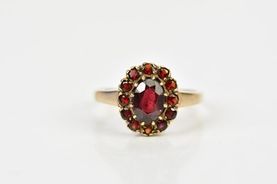 Lot 189 - A 9ct yellow gold garnet set flower head ring,...