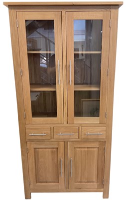 Lot 30 - A modern light oak display cabinet, with pair...