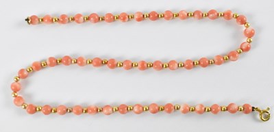 Lot 873 - A 9ct yellow gold mounted coral bead necklace,...